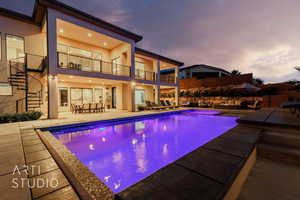 Pool at dusk with an outdoor living space, a patio area, and outdoor dining space