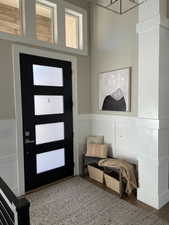 Foyer entrance with wood finished floors and a chandelier
