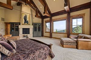 Bedroom with carpet flooring, a fireplace, high vaulted ceiling, and beamed ceiling