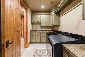 Laundry room with cabinet space, washer and clothes dryer, recessed lighting, and light tile patterned floors