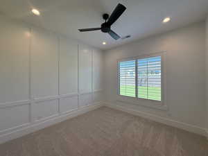 Unfurnished room featuring a ceiling fan, a decorative wall, light carpet, and recessed lighting