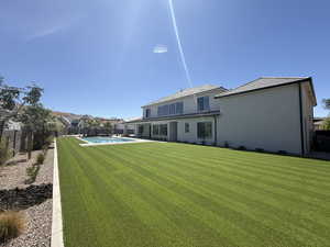 Rear view of property with a fenced backyard and stucco siding