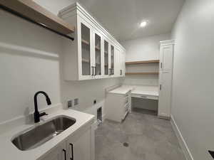 Washroom with electric dryer hookup, cabinet space, hookup for a washing machine, recessed lighting, and tile patterned floors