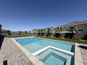 View of swimming pool with a residential view, a fenced backyard, and a pool with connected hot tub