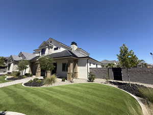 View of front facade with a chimney and stucco siding