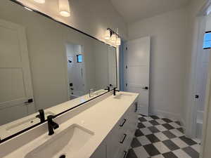 Bathroom featuring double vanity, tile patterned floors, and  shower combination