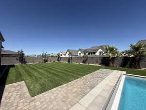 Fenced backyard featuring a residential view and a patio area