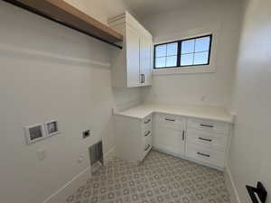 Washroom featuring hookup for an electric dryer, gas dryer hookup, cabinet space, and hookup for a washing machine