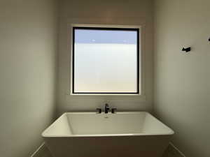 Full bathroom with a freestanding bath and baseboards