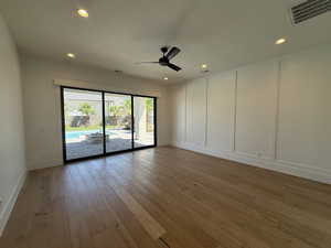 Unfurnished room featuring a decorative wall, hardwood / wood-style flooring, ceiling fan, and recessed lighting