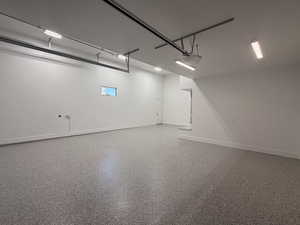Garage with baseboards and a garage door opener