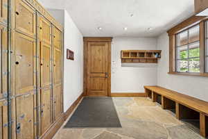 Mudroom with stone finish floors and recessed lighting