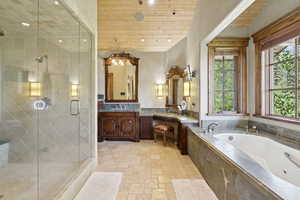 Full bath with a garden tub, vanity, a shower stall, stone finish flooring, and recessed lighting