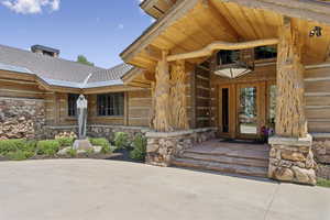 View of exterior entry with stone siding and a metal roof