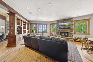 Living area with light wood-style floors, a fireplace, and recessed lighting