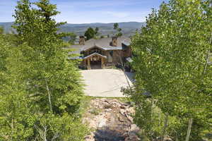 View of front of home with a chimney, a mountain view, and stone siding