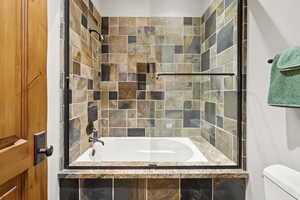 Bathroom featuring toilet and tiled shower / bath