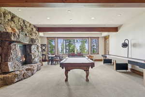 Rec room featuring beamed ceiling, carpet floors, pool table, recessed lighting, and a stone fireplace