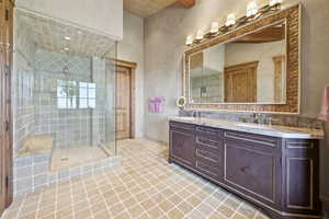 Bathroom with double vanity, a stall shower, and tile patterned floors