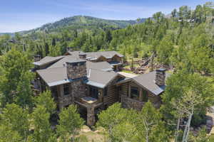 View from above of property with mountains and a heavily wooded area