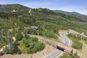 Aerial view of property's location with a mountainous background and a heavily wooded area