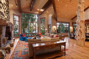 Living area with high vaulted ceiling, hardwood / wood-style floors, recessed lighting, and a wooden ceiling with exposed beams