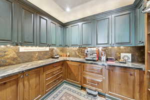 Kitchen featuring dark stone counters and decorative backsplash