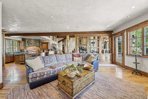 Living room with light wood finished floors, recessed lighting, and beam ceiling