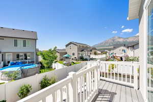 Wooden deck with a residential view, a mountain view, and a fenced backyard