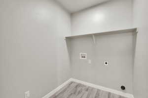 Laundry room featuring washer hookup, light wood-style flooring, and electric dryer hookup