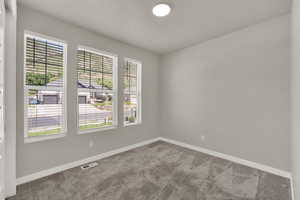 Carpeted spare room with baseboards