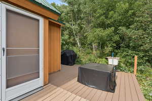 Wooden deck featuring area for grilling