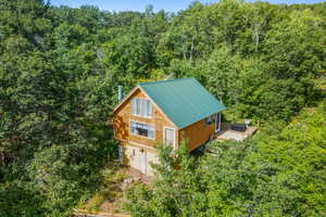Aerial view of property and surrounding area featuring a heavily wooded area
