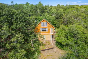 View of front of home featuring a forest view and stairs