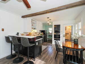 Kitchen with ornamental molding, open shelves, dark wood finished floors, white cabinets, and light countertops