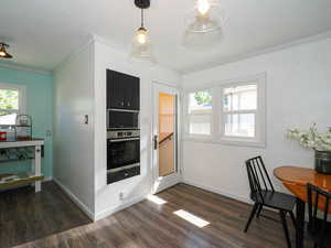 Dining area with plenty of natural light, dark wood-type flooring, crown molding, and a textured ceiling