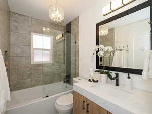 Bathroom with a chandelier, vanity, and shower / washtub combination