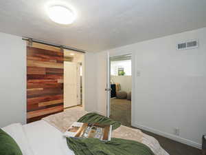 Carpeted bedroom featuring baseboards and a textured ceiling