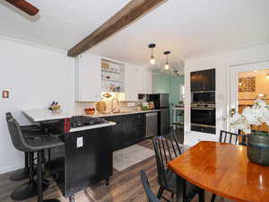 Kitchen featuring open shelves, white cabinetry, dark wood-style flooring, light countertops, and crown molding
