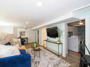 Living area with separate washer and dryer, recessed lighting, and a textured ceiling