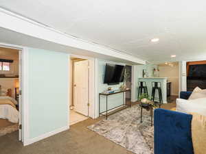 Carpeted living area with a textured ceiling and recessed lighting