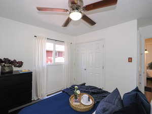 Bedroom featuring ceiling fan, a closet, and a textured ceiling