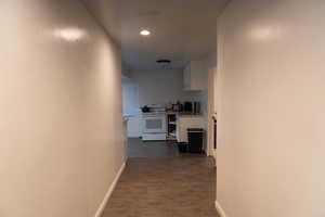 Hallway featuring dark wood finished floors and recessed lighting
