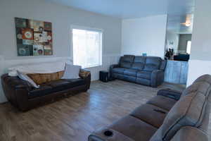 Living room featuring wood finished floors, a wainscoted wall, and plenty of natural light