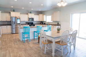 Dining space with recessed lighting, light wood finished floors, and a chandelier