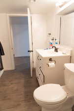 Half bathroom featuring vanity and dark wood-style flooring