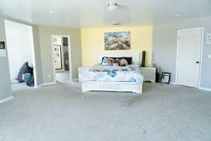 Bedroom with carpet flooring and freestanding refrigerator