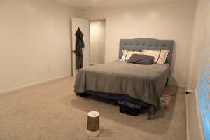 Bedroom with light colored carpet and baseboards