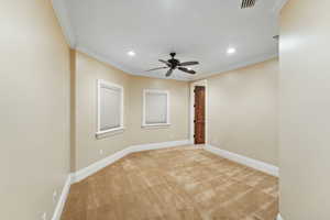 Empty room featuring light carpet, ceiling fan, ornamental molding, and recessed lighting