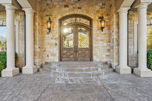 Entrance to property featuring stone siding and brick siding